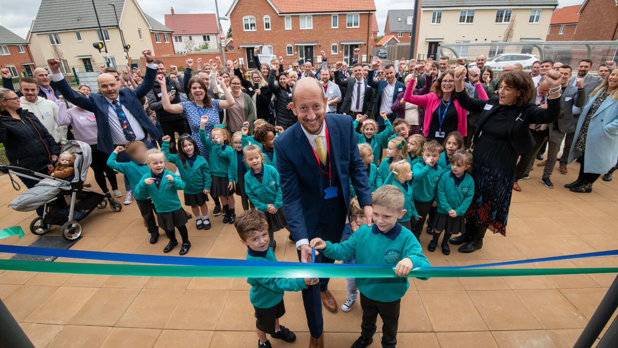 G Carter cutting the ribbon with pupils at the official opening of Grace Cook Primary and Nursery in Stowmarket